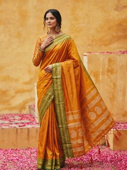 Sutriti - Sunset Glow: Vibrant Orange Silk Saree with Contrast Green Zari Border